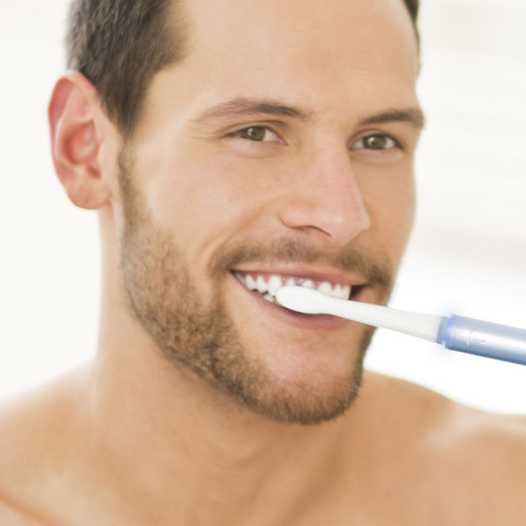 brush teeth with an electric toothbrush