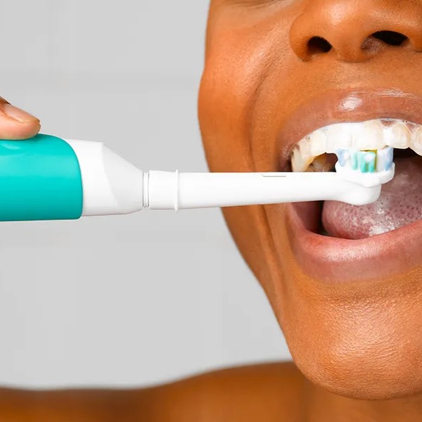 brush teeth with an electric toothbrush