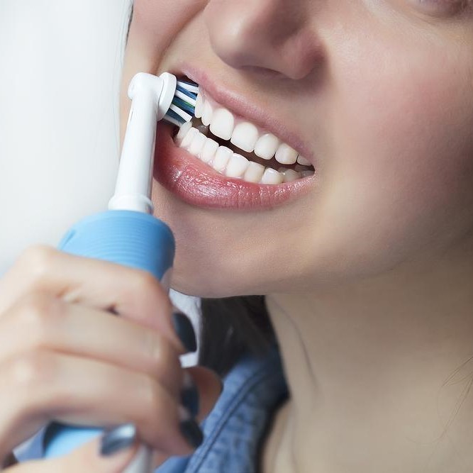 brushing teeth with electric toothbrush