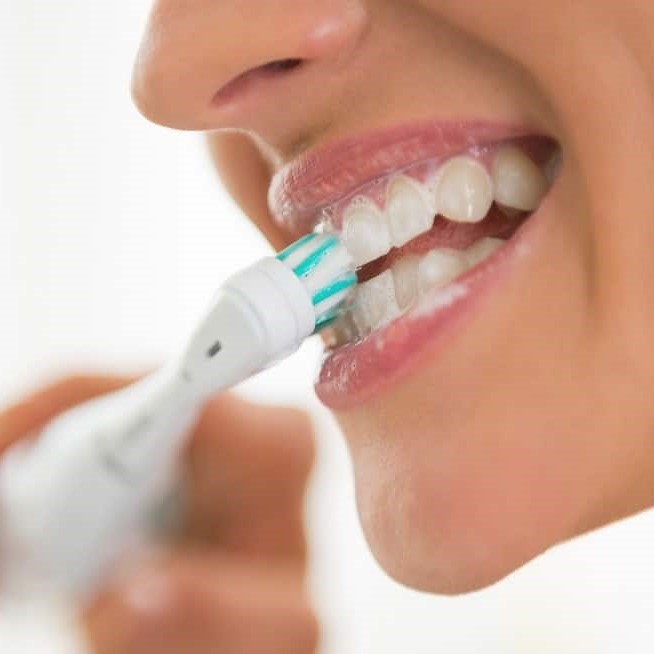 brushing teeth with electric toothbrush